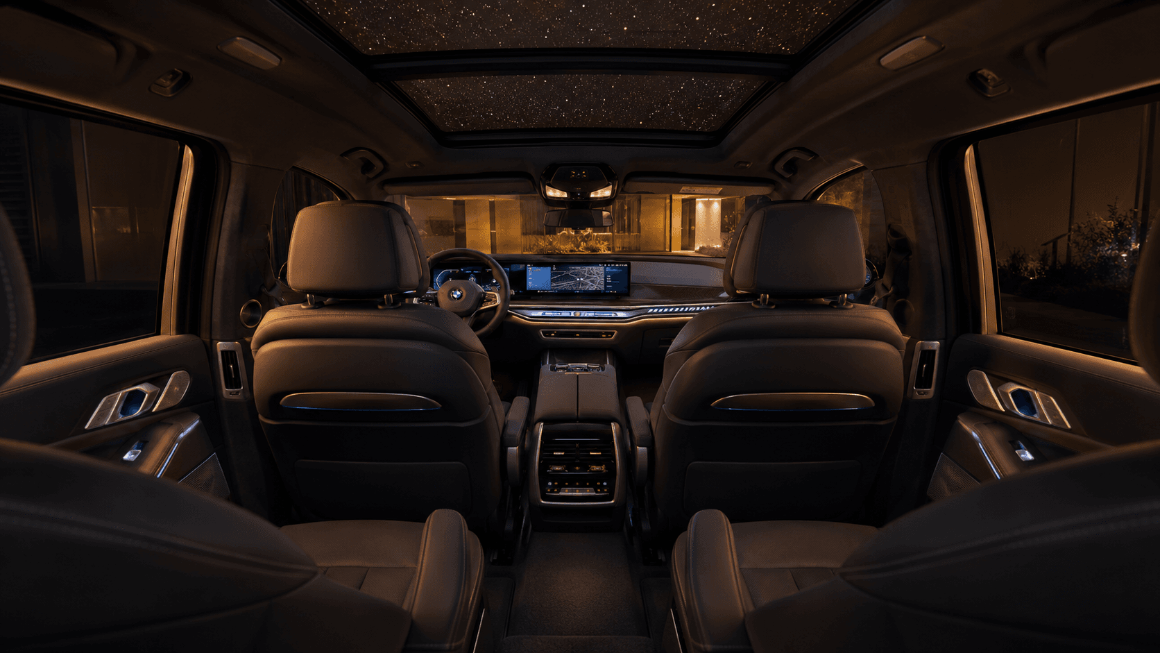 Second-row captain's chairs in the BMW X7 with Sky Lounge panoramic roof active.