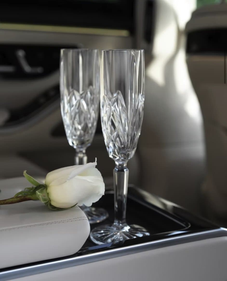 Chilled champagne flutes and silk napkin staged inside the Mercedes-Benz S580 rear console.